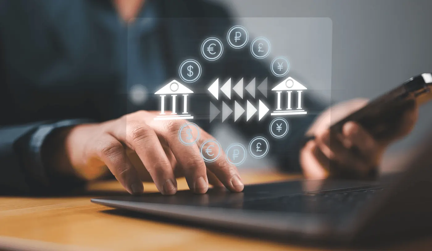 Virement entre deux banques représenté au-dessus d'un ordinateur portable, illustration du rapatriement de revenus